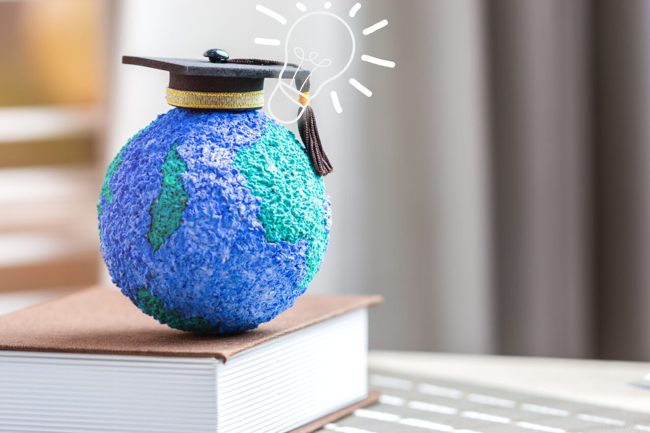 Concept of online learning graduation university study global international for long distane learning. Master degree hat on top globe book with lamp bulb. Creative for success in education abroad.